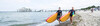 Pärchen mit SUP- Boards am Strand